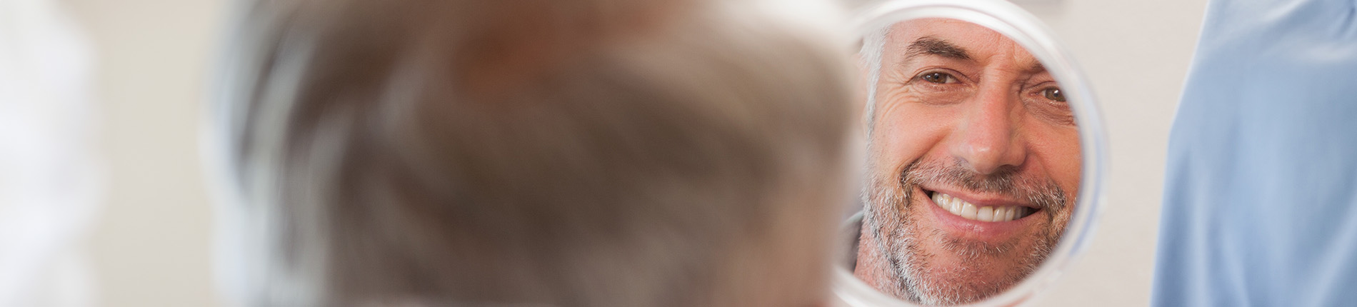 The image is a photograph of a woman with light skin, smiling at the camera. She appears to be in her late twenties or early thirties and has long hair. Her eyes are looking directly at the camera, and she is holding up her index finger near her mouth as if she s making a point or emphasizing something. The background is plain and light-colored, which suggests that this could be a stock photo used for various purposes such as advertising, personal branding, or lifestyle content.