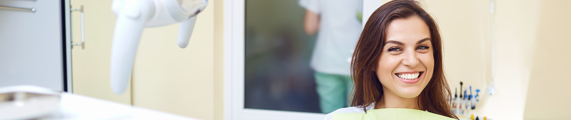 A well-lit reception area with a desk, computer monitor, and potted plant.